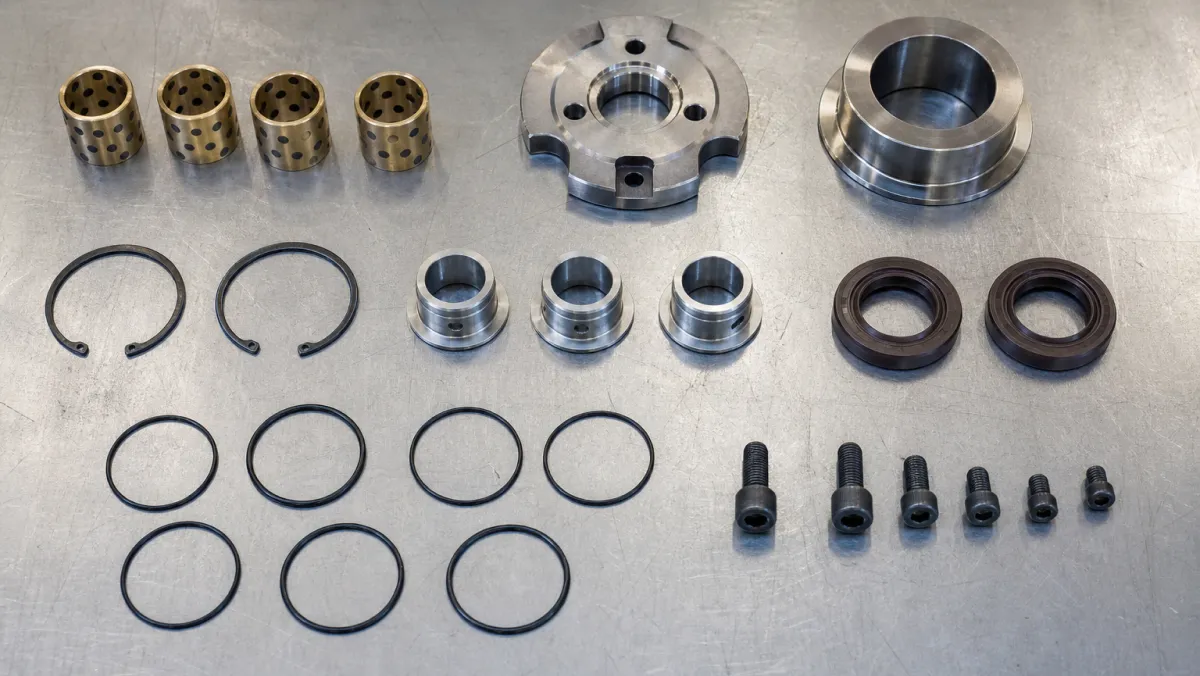 Turbocharger repair kit components laid out including journal bearings, thrust bearing, piston rings and seals